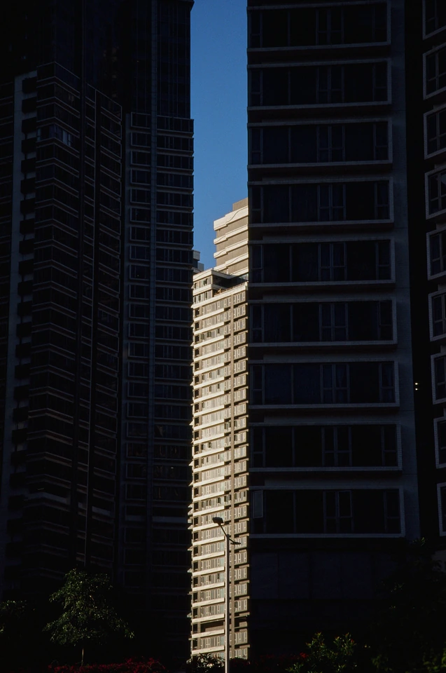 Sunlight falling on a building between shadowed towers